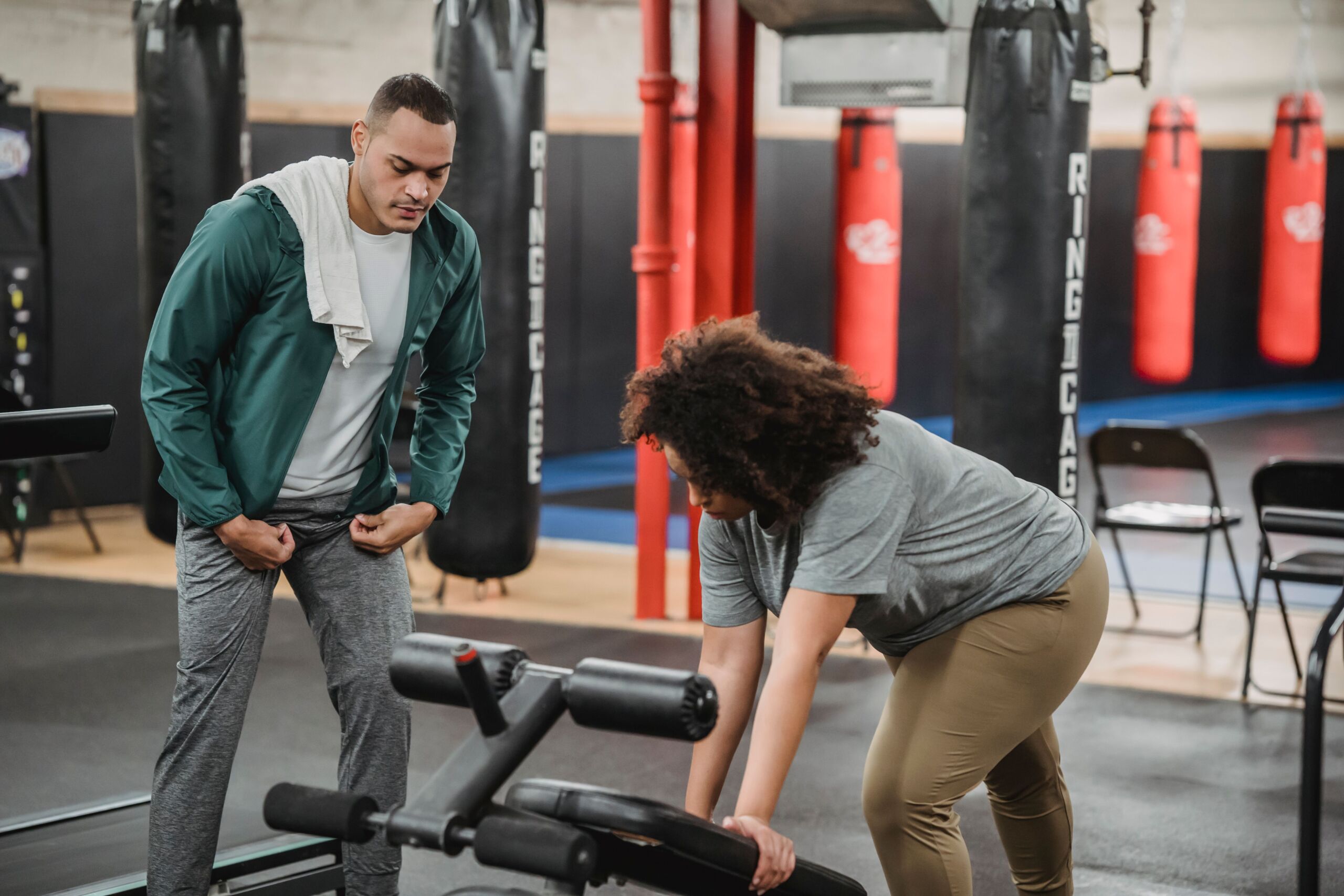 A personal trainer guiding a client during a gym workout